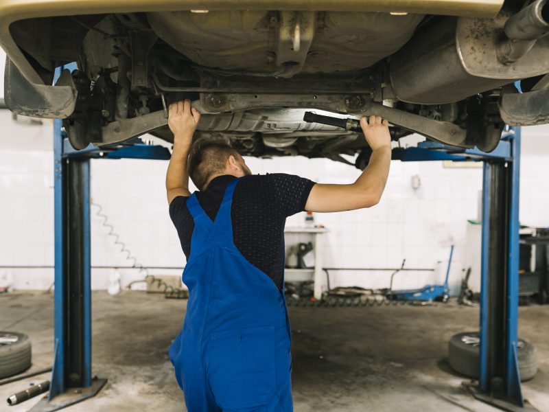 reparadores-que-examinan-fondo-coche